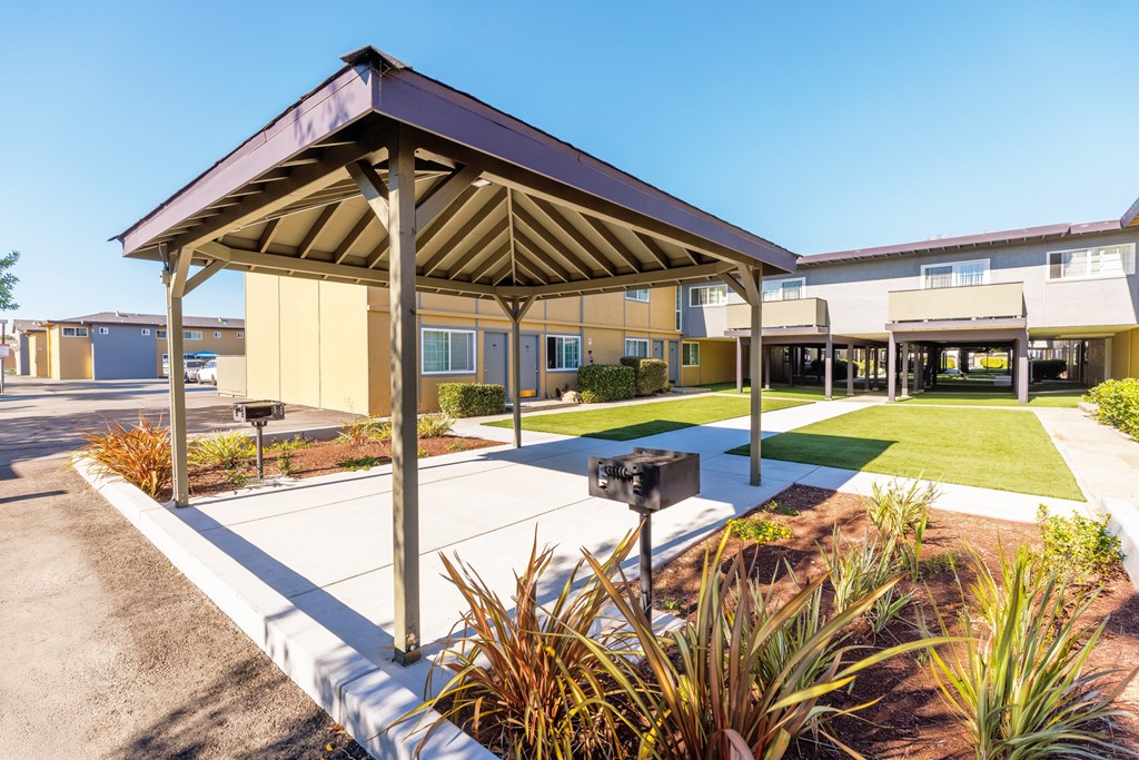 A building with a brown roof and a parking lot in front.