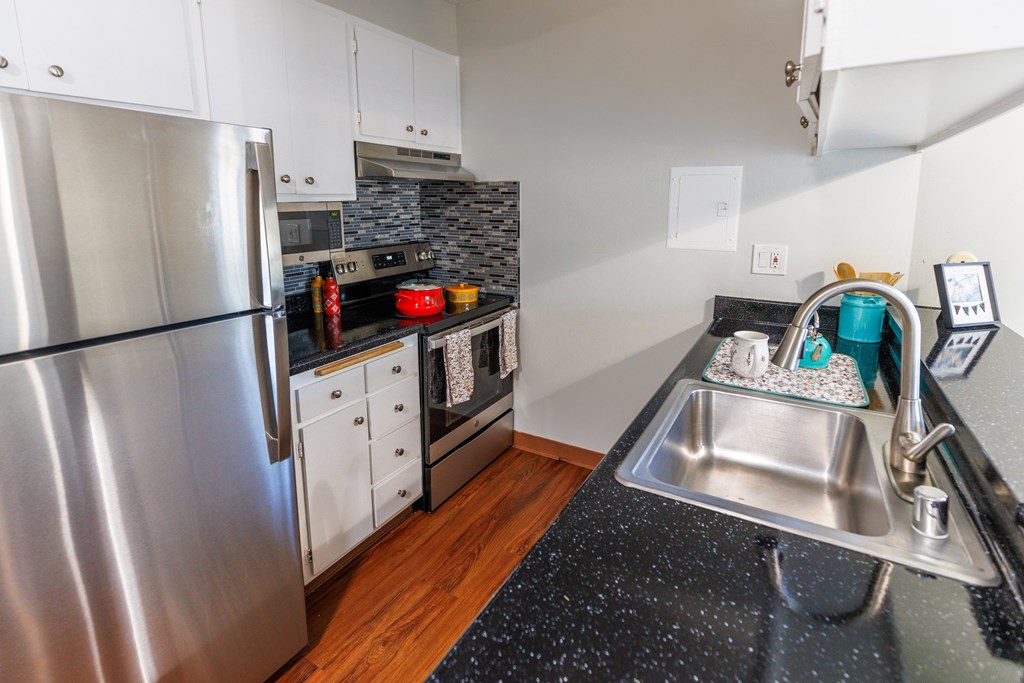 A kitchen with a stainless steel refrigerator and a sink.