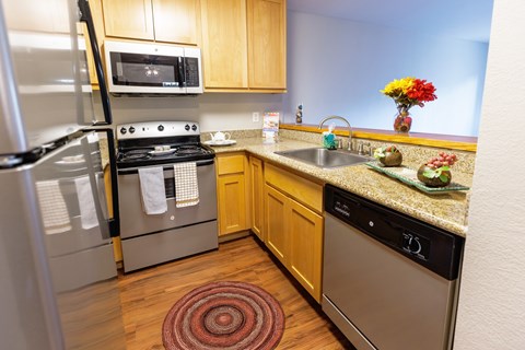 A kitchen with a refrigerator, oven, and microwave.