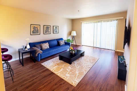 A living room with a blue couch and a coffee table.
