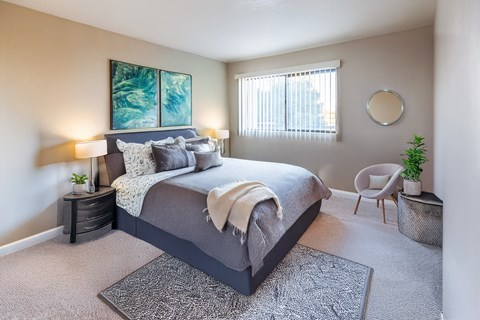 A bedroom with a large bed and a painting on the wall.