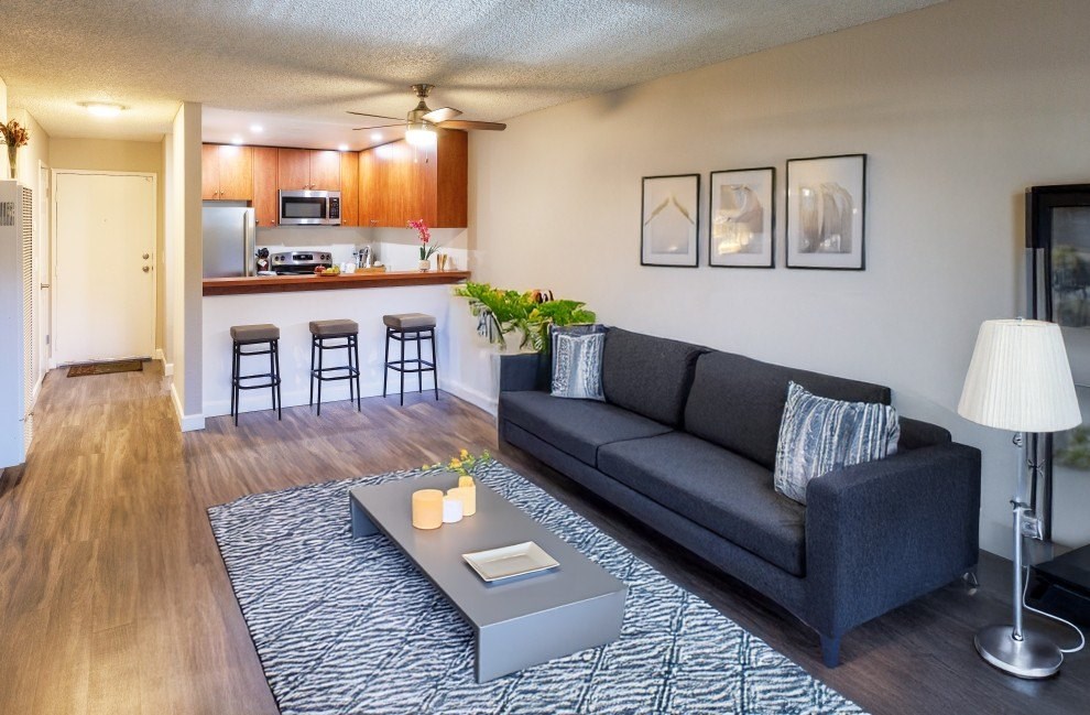 A living room with a grey couch and a coffee table in front of it.