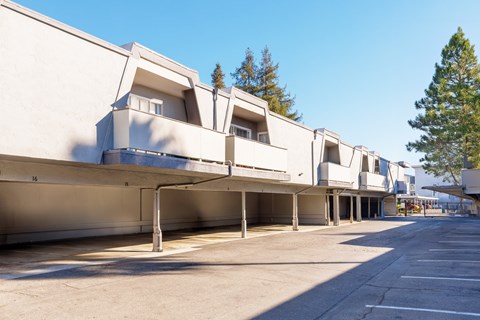 A long row of white buildings with a clear blue sky above.