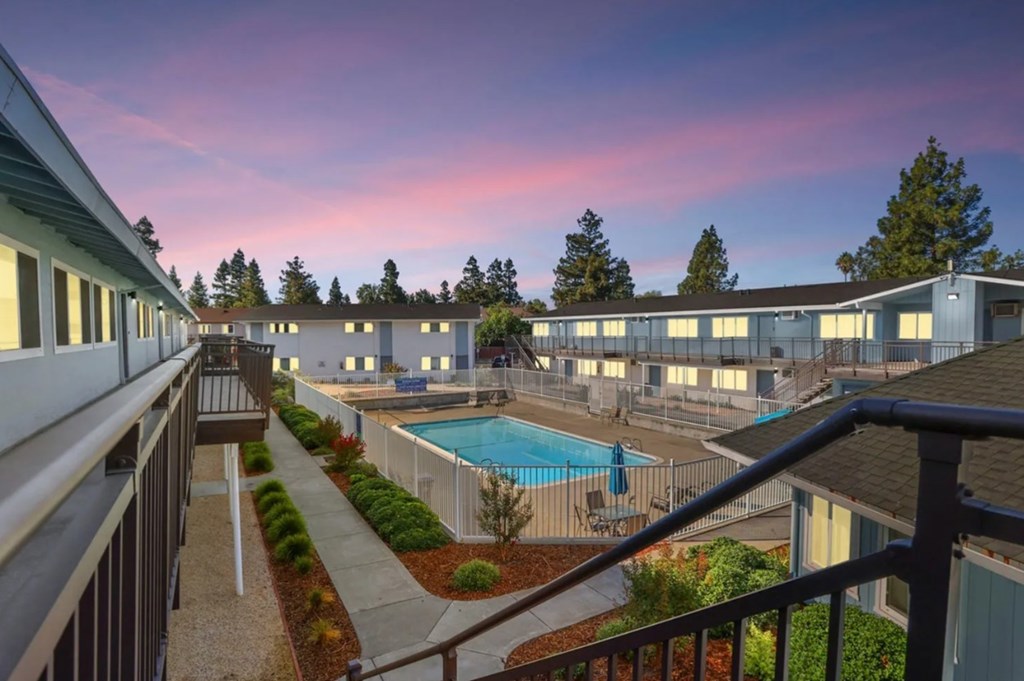 A view of a pool and apartment complex from a balcony.