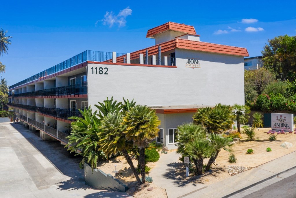 A white building with a red roof and the number 1182 on it.