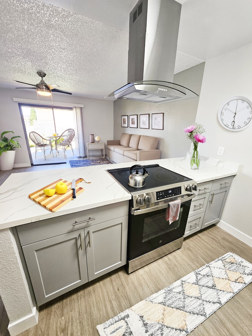A modern kitchen with a large island and a stove top oven.