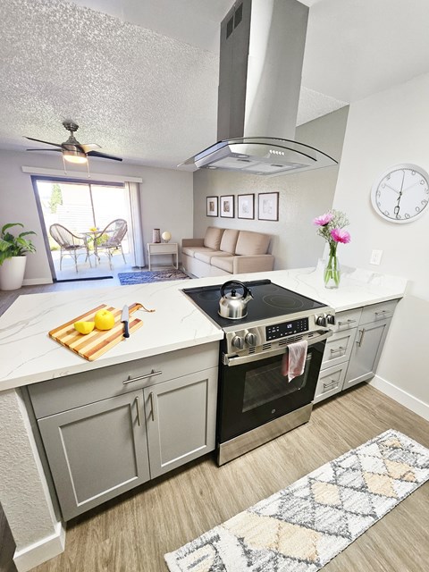 A modern kitchen with a large island and a stove top oven.