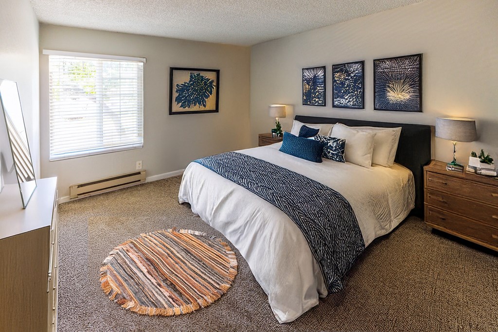 A bedroom with a large bed and a carpeted floor.