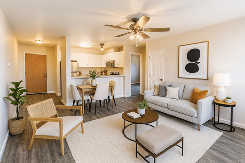 A living room with a white couch, a wooden chair, and a ceiling fan.