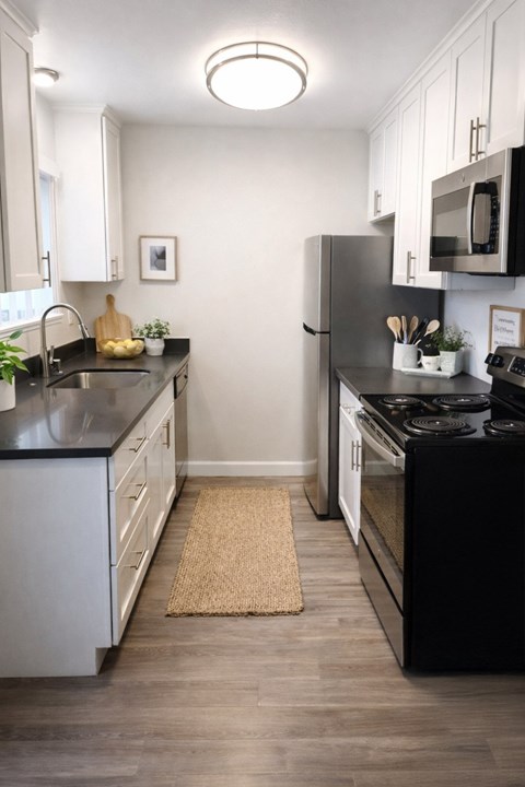 A kitchen with black countertops and white cabinets.