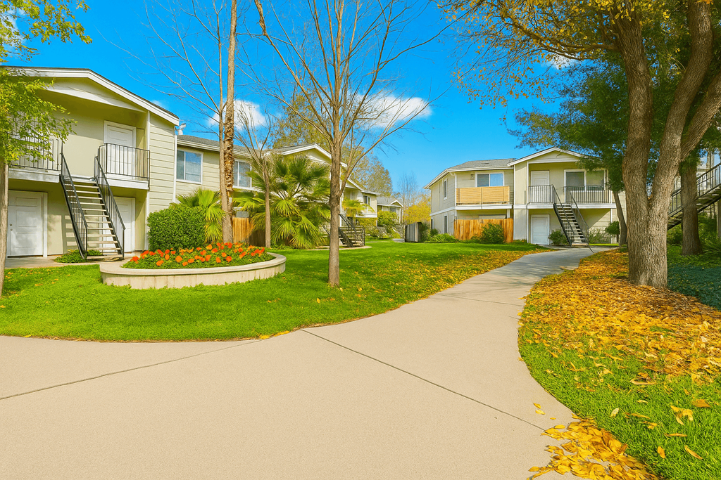 A residential street with houses on both sides and a sidewalk in the foreground.
