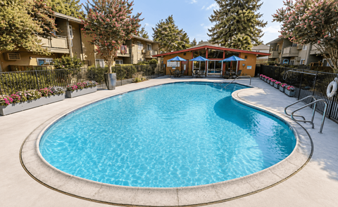 A swimming pool surrounded by a fence and trees.