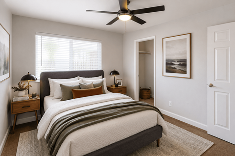 A bedroom with a large bed and a ceiling fan.