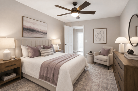 A bedroom with a bed, chair, and ceiling fan.