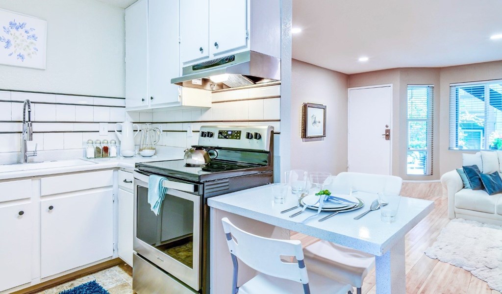 A modern kitchen with a dining table set for two.