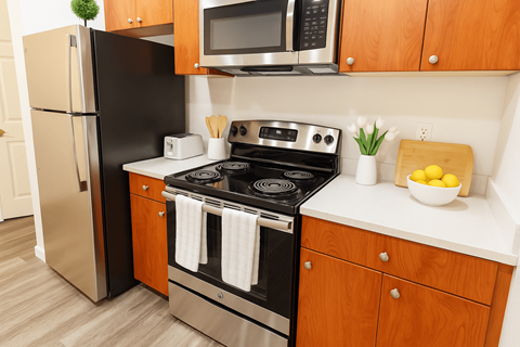 A modern kitchen with a black stove and wooden cabinets.