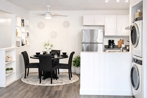 A modern kitchen with a dining table set for four.