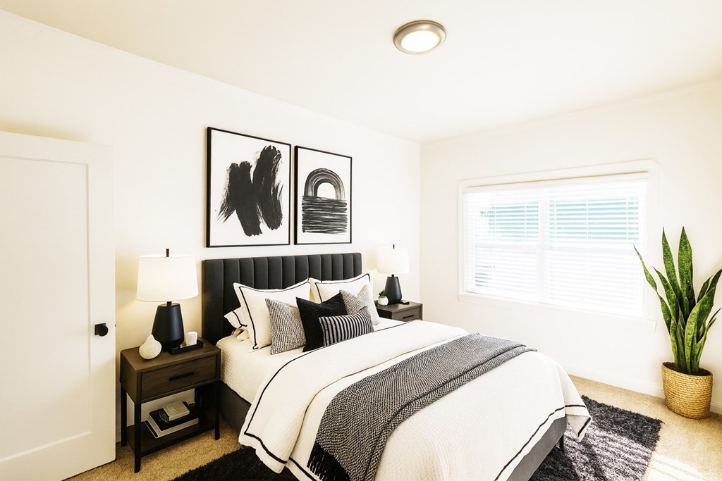 A bedroom with a large bed and a painting above it.