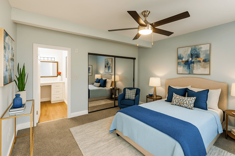 A bedroom with a large bed and a ceiling fan.