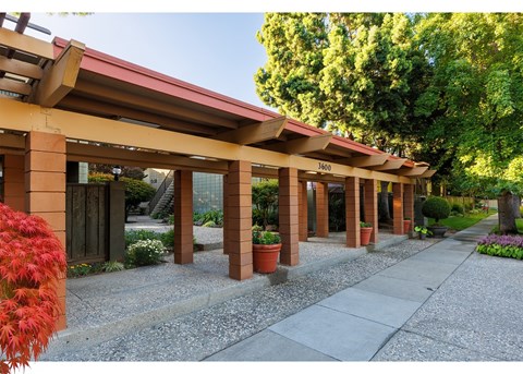 A building with a red roof and pillars with a sign that says 3400.