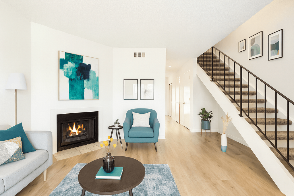 A living room with a fireplace and a blue chair.