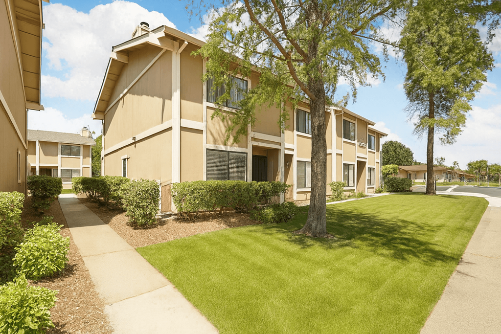 Apartment complex with a green lawn in front.