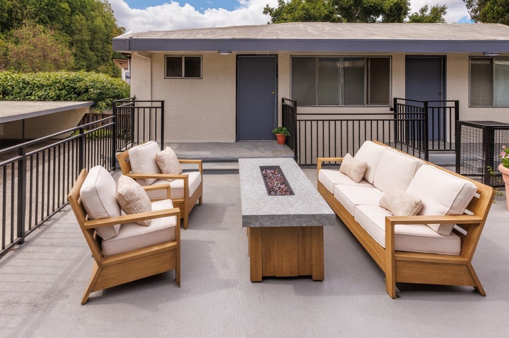 a patio with couches and a table in front of a house