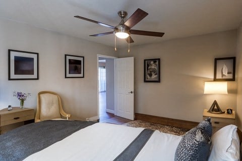 a bedroom with a large bed and a ceiling fan