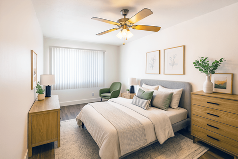A bedroom with a bed, nightstand, and chair.