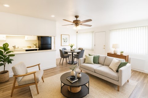 A living room with a couch, chairs, and a dining table.