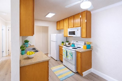 A kitchen with wooden cabinets and white appliances.