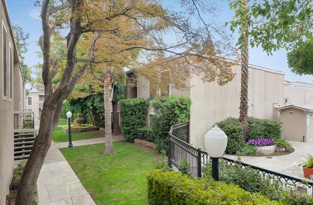 the backyard of a house with a yard and trees and a sidewalk