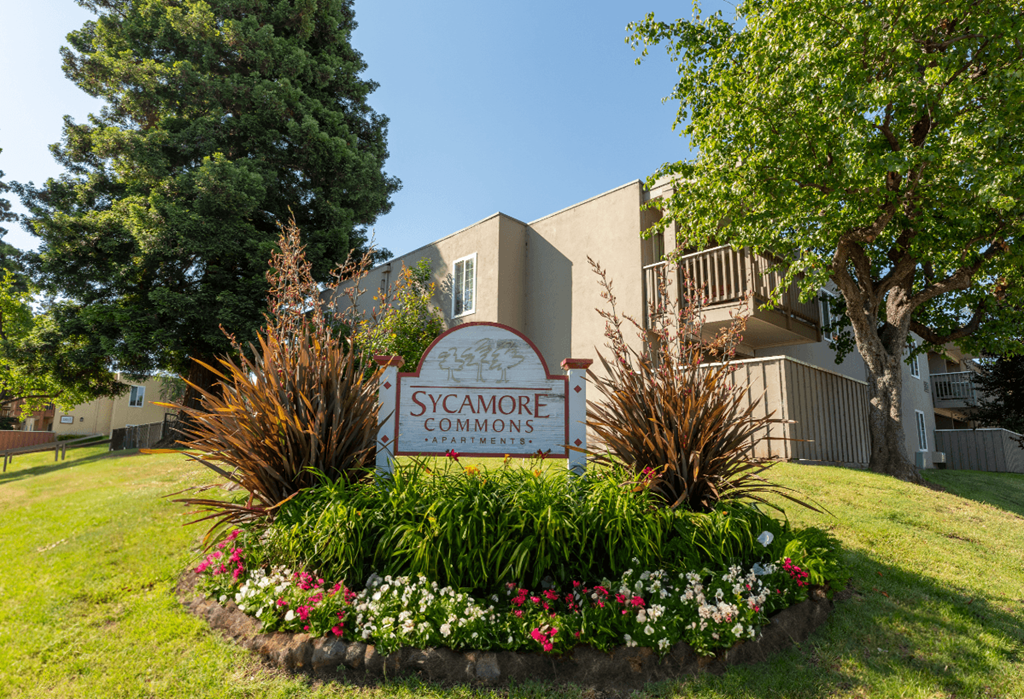 A sign that says Sycamore Commons in front of a building.