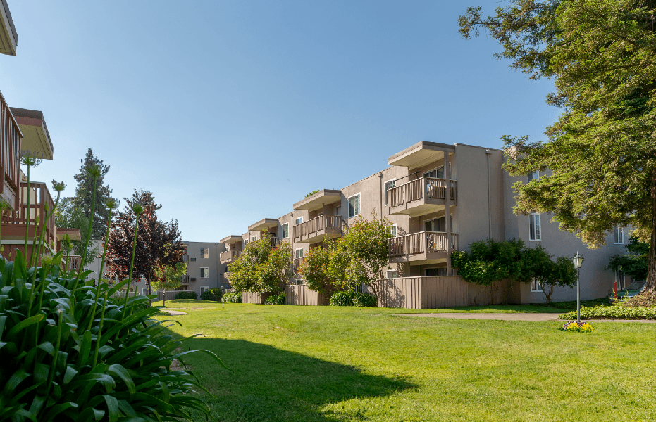 A grassy area in front of apartment buildings.