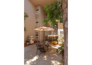 A patio with a table and chairs under an umbrella.