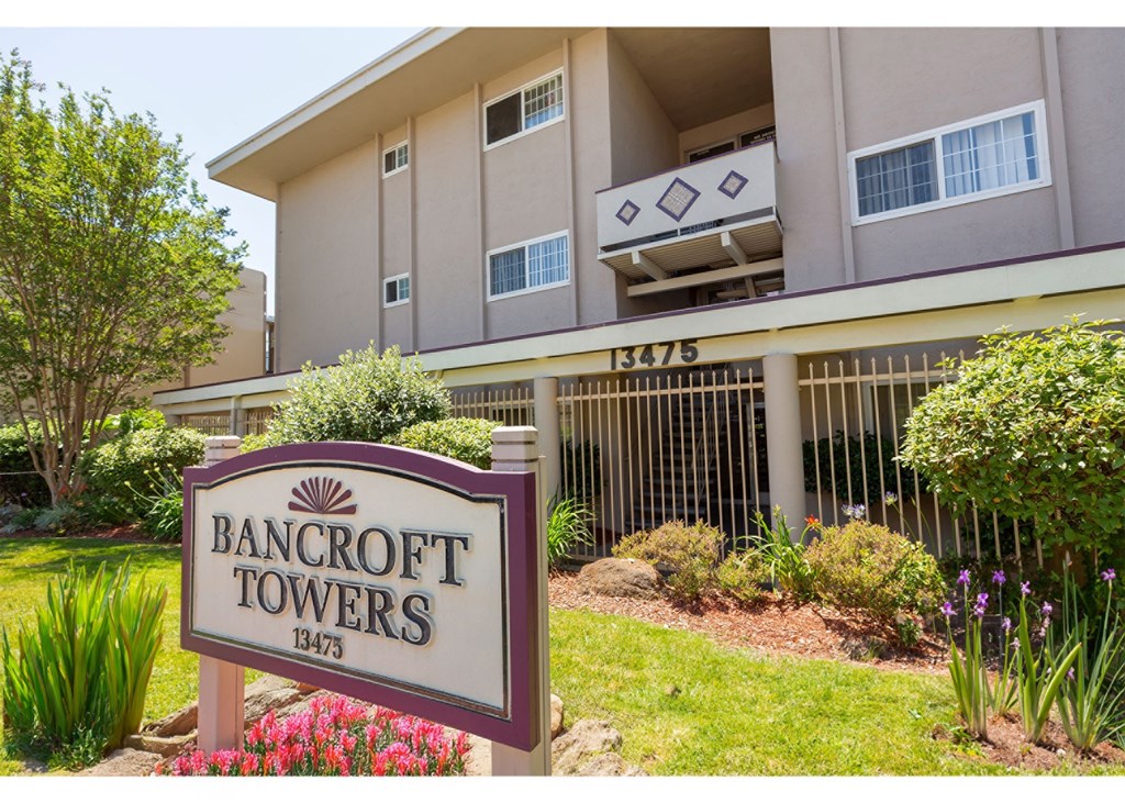 A sign for Bancroft Towers stands in front of a building.