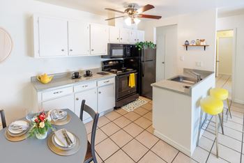 A kitchen with a table set for two.