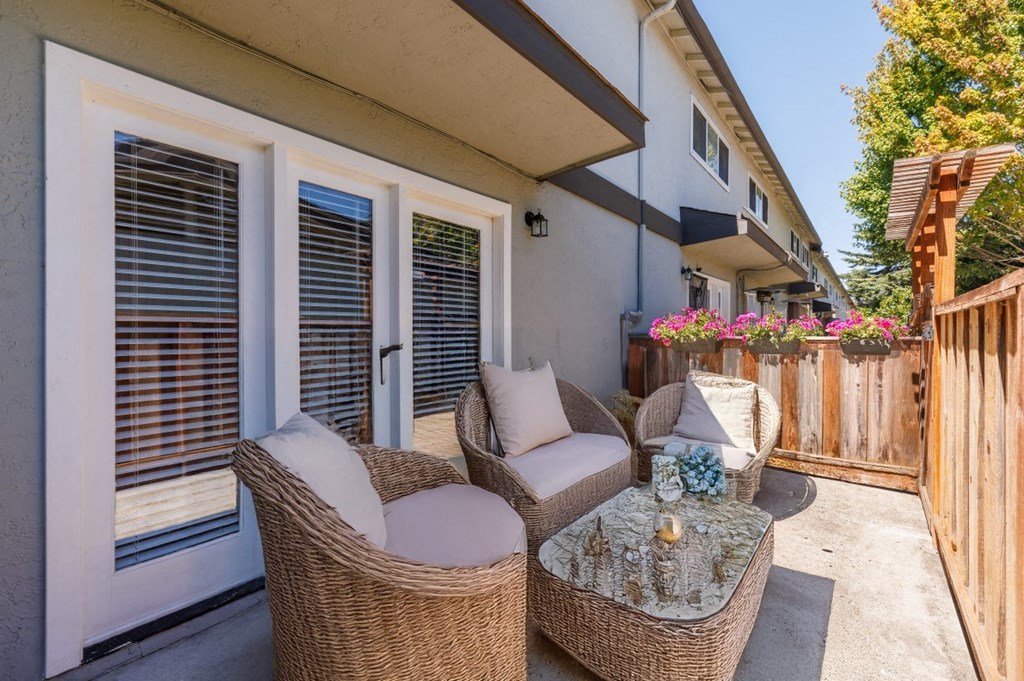 a patio with wicker chairs and a table on a patio