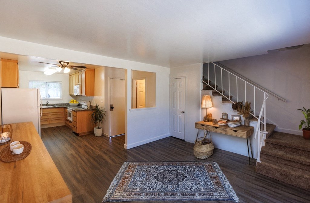 the view of a living room with a staircase and a kitchen