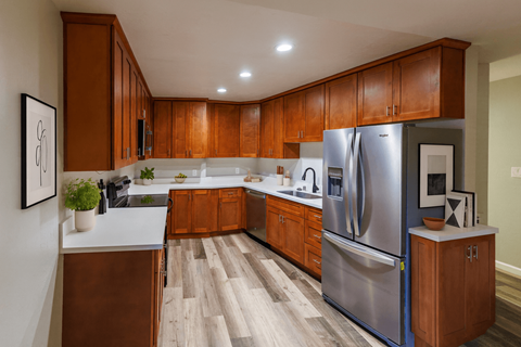 A modern kitchen with wooden cabinets and a stainless steel refrigerator.