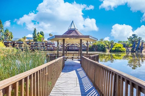 a wooden bridge leading to a gazebo on the water