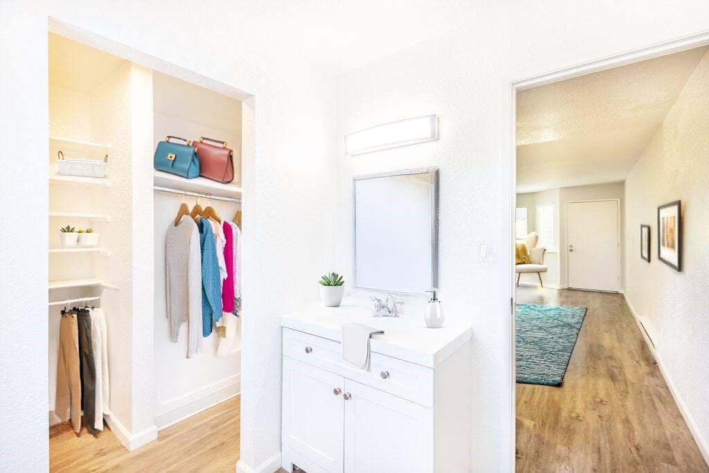 A bathroom with a white vanity and a mirror above it.