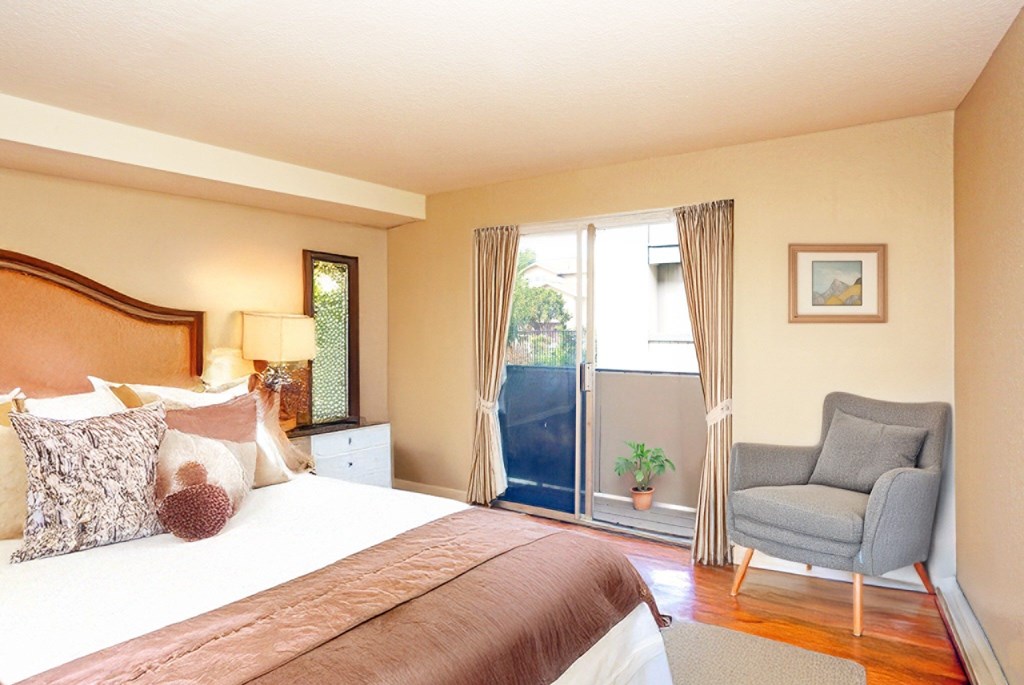 A bedroom with a large bed and a chair.