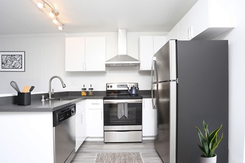 A modern kitchen with stainless steel appliances and white cabinets.