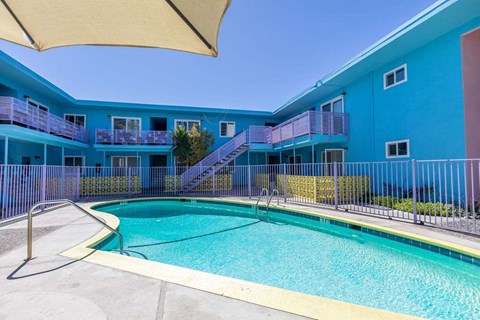 A blue building with a pool in front.