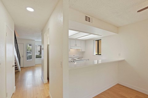 A white kitchen with a counter and a window.