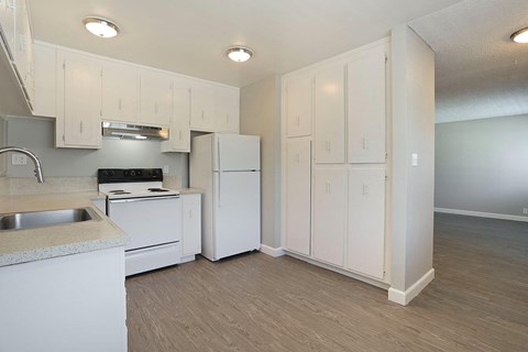 A kitchen with white cabinets and appliances.