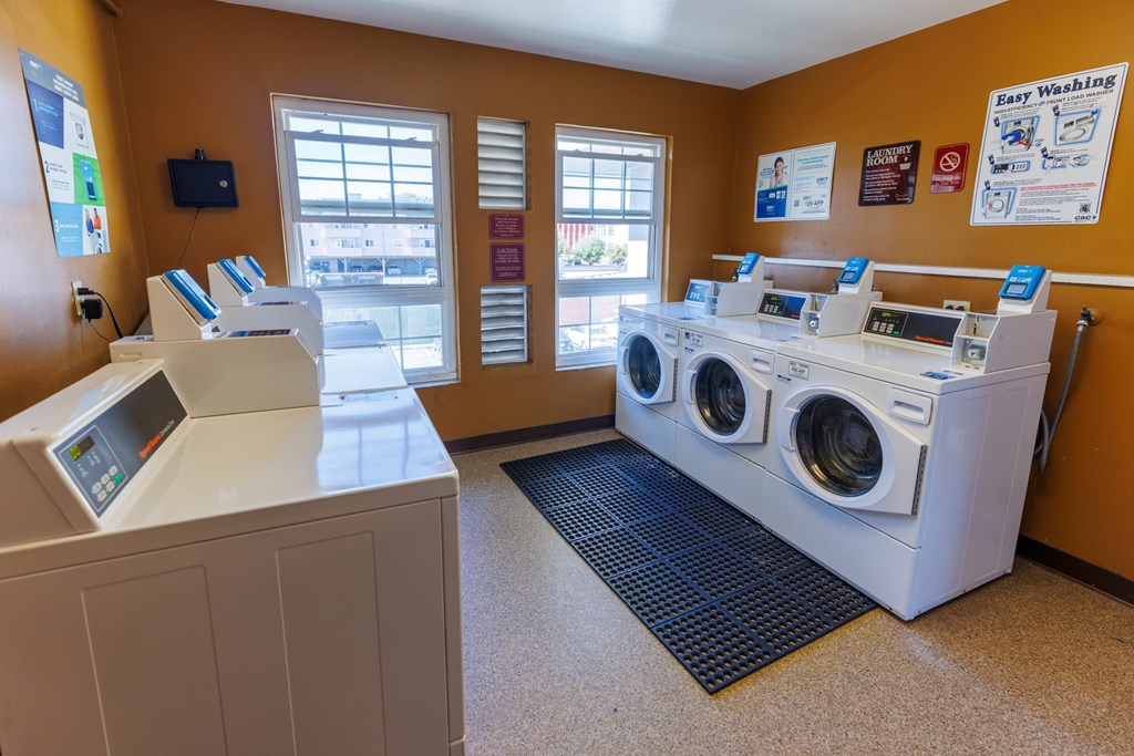 A laundromat with a washer and dryer and a payment machine.