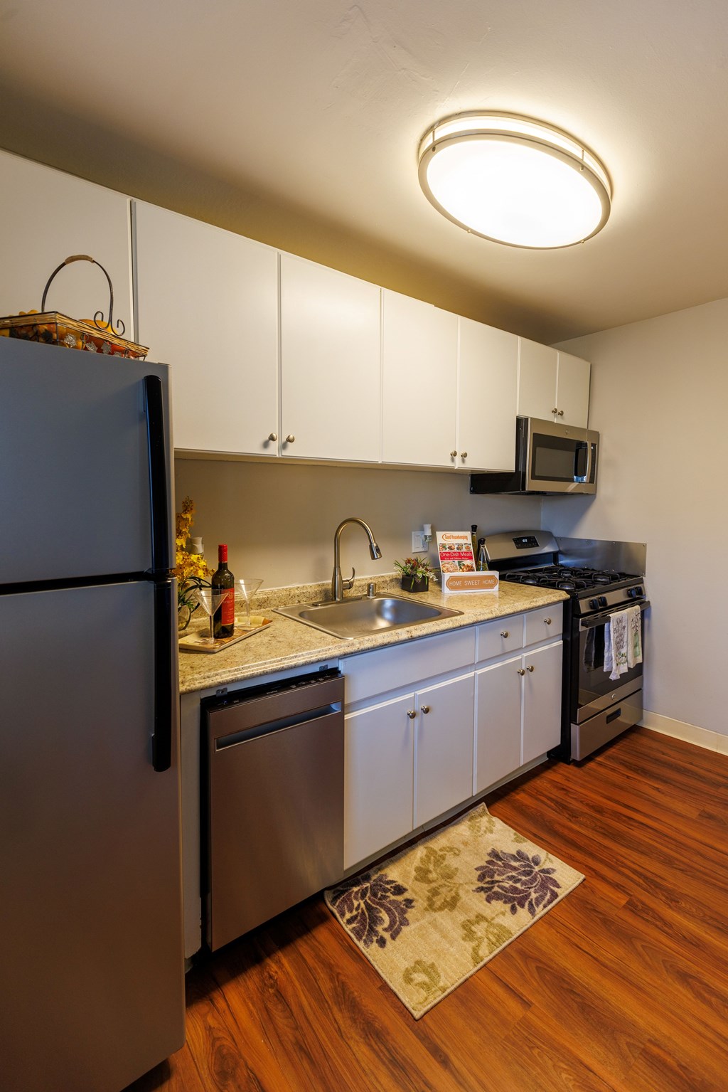 A kitchen with a refrigerator, microwave, and oven.