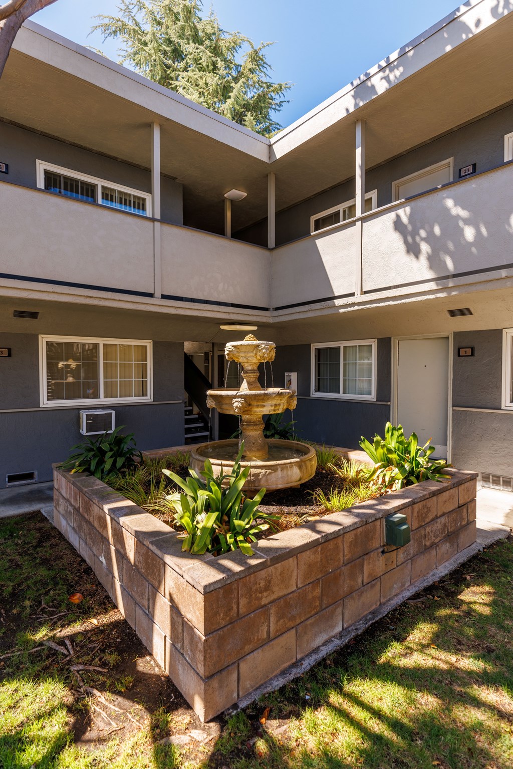 A courtyard with a fountain and a wall.